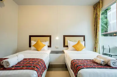 two beds sitting next to each other in a room at Tri's Miracle Kata Beach Side in Kata Beach