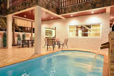 a swimming pool in a house with a table and chairs at Unique&Nice 7BD pool villa in heart Nanai Patong in Patong Beach