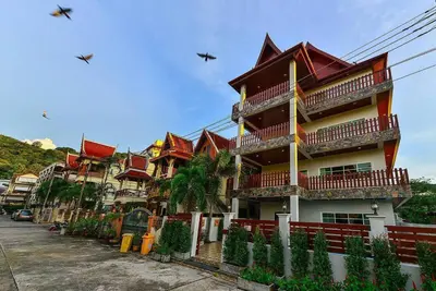 a building with red roofs on a street at Unique&Nice 7BD pool villa in heart Nanai Patong in Patong Beach