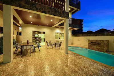 a house with a pool and a table and chairs at Unique&Nice 7BD pool villa in heart Nanai Patong in Patong Beach