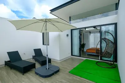 a living room with two chairs and an umbrella at 3bdr Townhouse In Laguna Park #118 by Capital Pro in Thalang