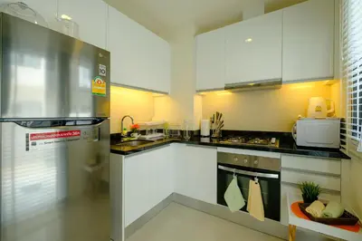 a kitchen with white cabinets and a stainless steel refrigerator at 3bdr Townhouse In Laguna Park #118 by Capital Pro in Thalang
