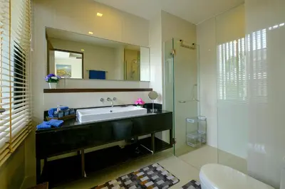 a bathroom with a sink and a mirror and a shower at 3bdr Townhouse In Laguna Park #118 by Capital Pro in Thalang