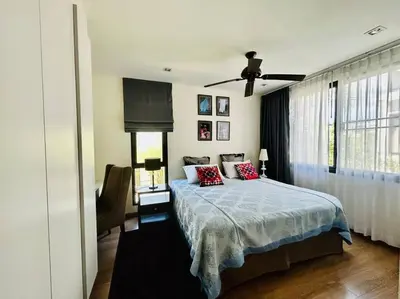 a bedroom with a bed and a ceiling fan at Country club townhouse in Bang Tao Beach