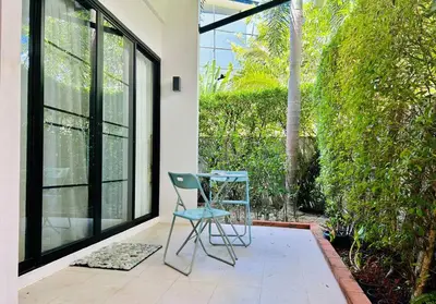 a table and a chair sitting on a patio at Country club townhouse in Bang Tao Beach