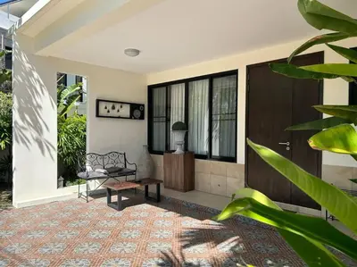 a house with a porch with a bench and windows at Country club townhouse in Bang Tao Beach