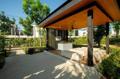 a pavilion in a park with trees and a building at Country club townhouse in Bang Tao Beach