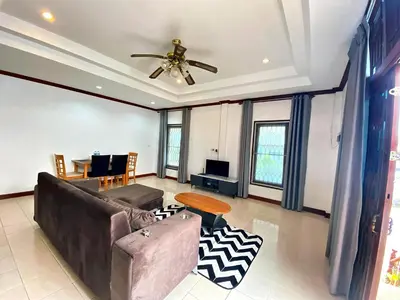 a living room with a couch and a ceiling fan at Peaceful 2BR Garden Retreat Bangtao Beach A2 in Ban Thalat Choeng Thale