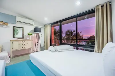 a bedroom with a bed and a large window at Eco Hostel in Phuket Town