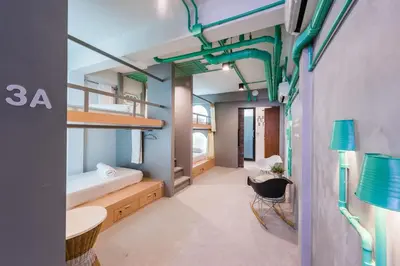 a room with a bunk bed and a desk at Eco Hostel in Phuket Town