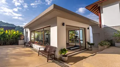 a house with two chairs on a patio at Villa Varya in Amphoe Thalang