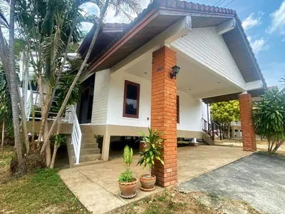a white house with palm trees in front of it at 2BR Private Villa Natural Stone Style A3 in Ban Thalat Choeng Thale
