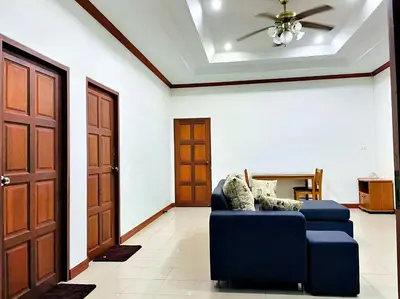 a living room with a blue couch and a ceiling fan at 2BR Private Villa Natural Stone Style A3 in Ban Thalat Choeng Thale