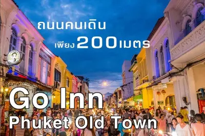a crowd of people walking down a street at night at xx GO INN Phuket Old Town ภูเก็ตโอลทาวน์ ย่านเมืองเก่า in Phuket Town