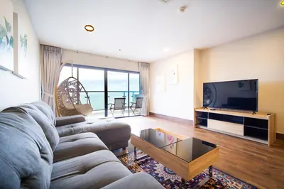 a living room with a couch and a tv at Patong tower Superior Seaview 4BR-2102 in Patong Beach