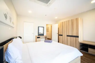 a bedroom with a white bed and a wooden cabinet at Patong tower Superior Seaview 4BR-2102 in Patong Beach