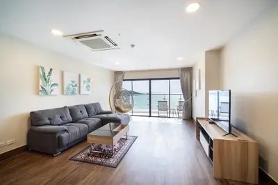 a living room with a couch and a television at Patong tower Superior Seaview 4BR-2102 in Patong Beach