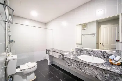 a bathroom with a toilet and a sink and a mirror at Patong Tower Superior Seaview 4BR-2101 in Patong Beach