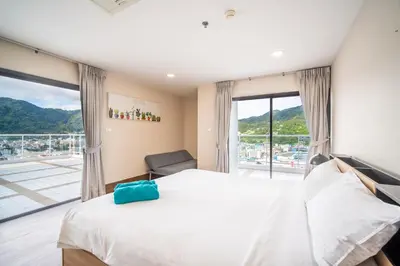 a bedroom with a large bed and a large window at Patong Tower Superior Seaview 4BR-2101 in Patong Beach