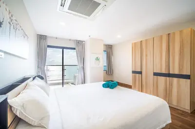 a bedroom with a large white bed and a window at Patong Tower Superior Seaview 4BR-2101 in Patong Beach