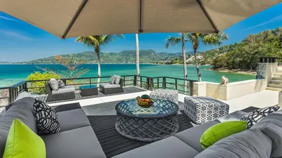 an outdoor patio with a view of the ocean at Villa Purissara in Phuket Town