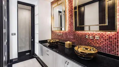 a bathroom with two gold sinks on a black counter at Villa Purissara in Phuket Town