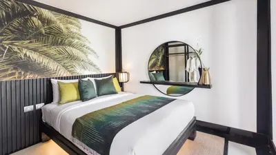 a bedroom with a bed and a mirror at Villa Purissara in Phuket Town