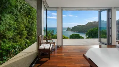 a bedroom with a view of the ocean at Villa Lomchoy in Phuket Town