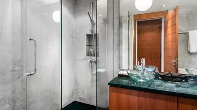 a bathroom with a glass shower and a sink at Villa Lomchoy in Phuket Town