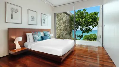 a bedroom with a bed and a large window at Villa Lomchoy in Phuket Town