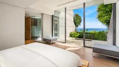 a bedroom with a bed and a view of the ocean at Villa Saengootsa in Phuket Town
