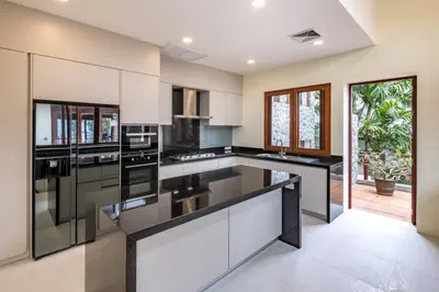 a kitchen with white cabinets and black counter tops at Villa Horizon in Phuket Town