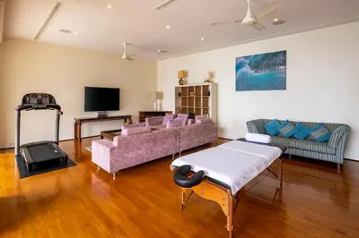 a living room with two couches and a tv at Villa Fah Sai in Phuket Town