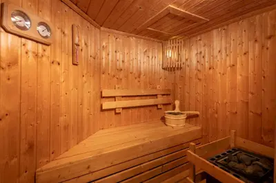 a wooden sauna with a bench and a bucket at Villa Fah Sai in Phuket Town