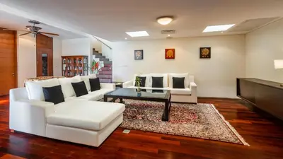 a living room with white couches and a coffee table at Villa Viman in Kathu