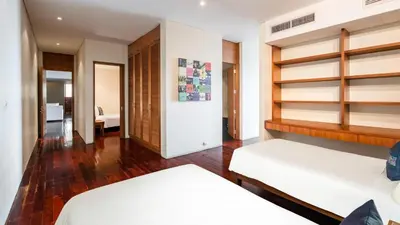 two beds in a bedroom with wooden shelves at Villa Viman in Kathu