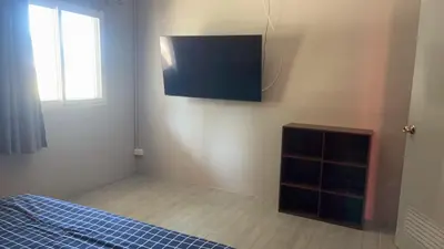 a bedroom with a bed and a tv on the wall at KARON STUDIO APARTMENT in Karon Beach