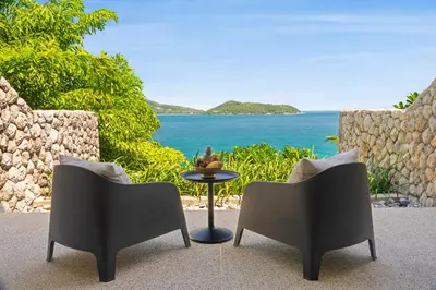 two chairs and a table with a view of the ocean at Villa Hale Malia in Kathu