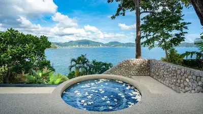 a bath tub with a view of the water at Villa Rom Trai in Kathu