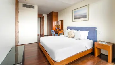 a bedroom with a large white bed and a table at Villa Rom Trai in Kathu