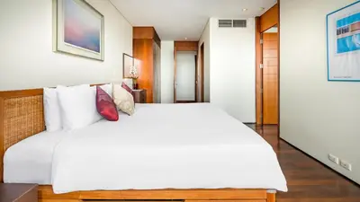 a bedroom with a large white bed with white pillows at Villa Rom Trai in Kathu