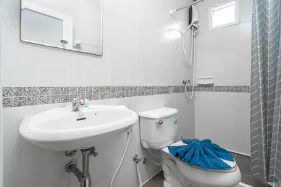 a white bathroom with a sink and a toilet at Nice to meat you Rooms in Patong Beach