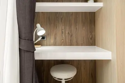a room with a desk and a stool and a lamp at Calypso Garden Residences by Beringela in Phuket Town