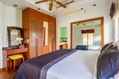 a bedroom with a large bed and a mirror at Recommend a warm Thai style private swimming pool villa with convenient traffic and living, walking 700 meters to the the beach in Kamala Beach