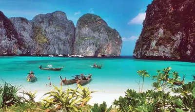 a group of boats on a beach in the water at Coco Bella Hotel in Phi Phi Don