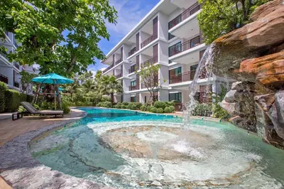 a fountain in front of a building with a pool at The Title Condo by Tropiclook in Rawai Beach