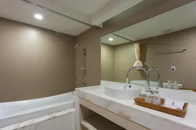 a bathroom with a sink and a tub at Coral Inn in Karon Beach