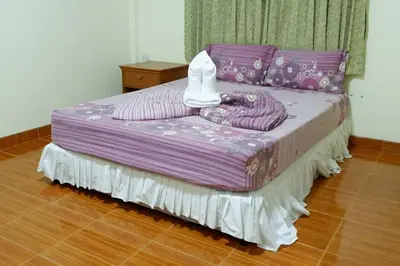 a bed with a purple comforter on top of it at Harmony House-SHA Plus in Phi Phi Don