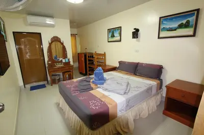 a bedroom with a bed and a dresser and a mirror at Harmony House-SHA Plus in Phi Phi Don