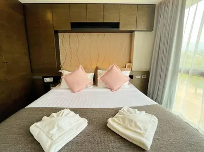 a hotel room with a bed with pink pillows at Citygate in Kamala beach - Perfect Stay for Digital Work in Kamala Beach